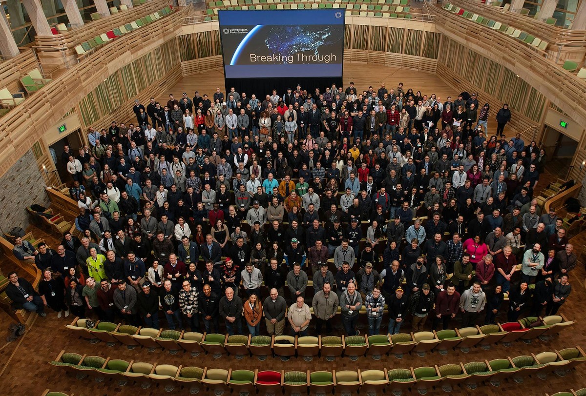 Hundreds of CFS employees in a large auditorium looking at the camera.